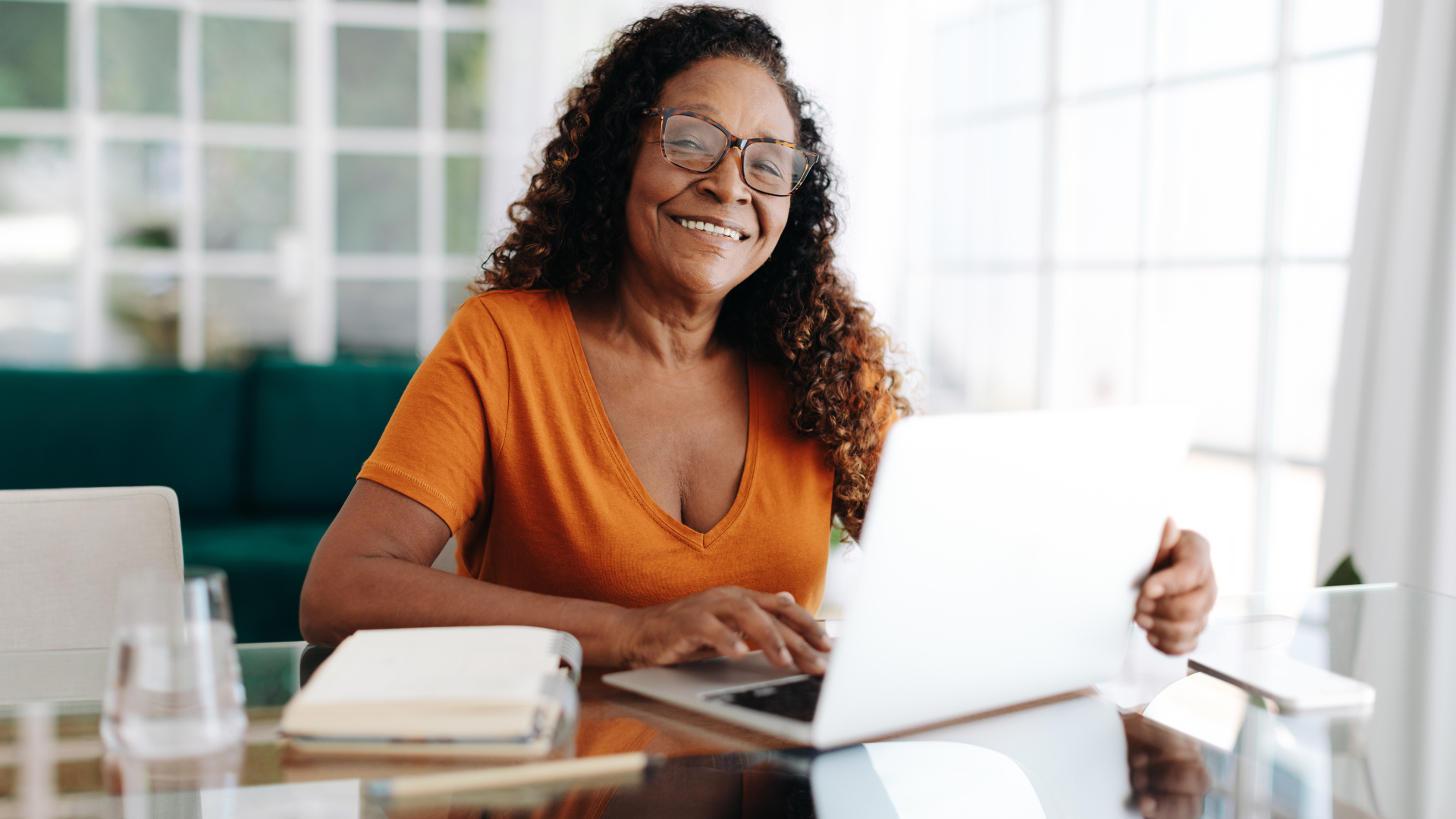 Person working remotely smiling at the camera, feeling connected and included to her team and company culture