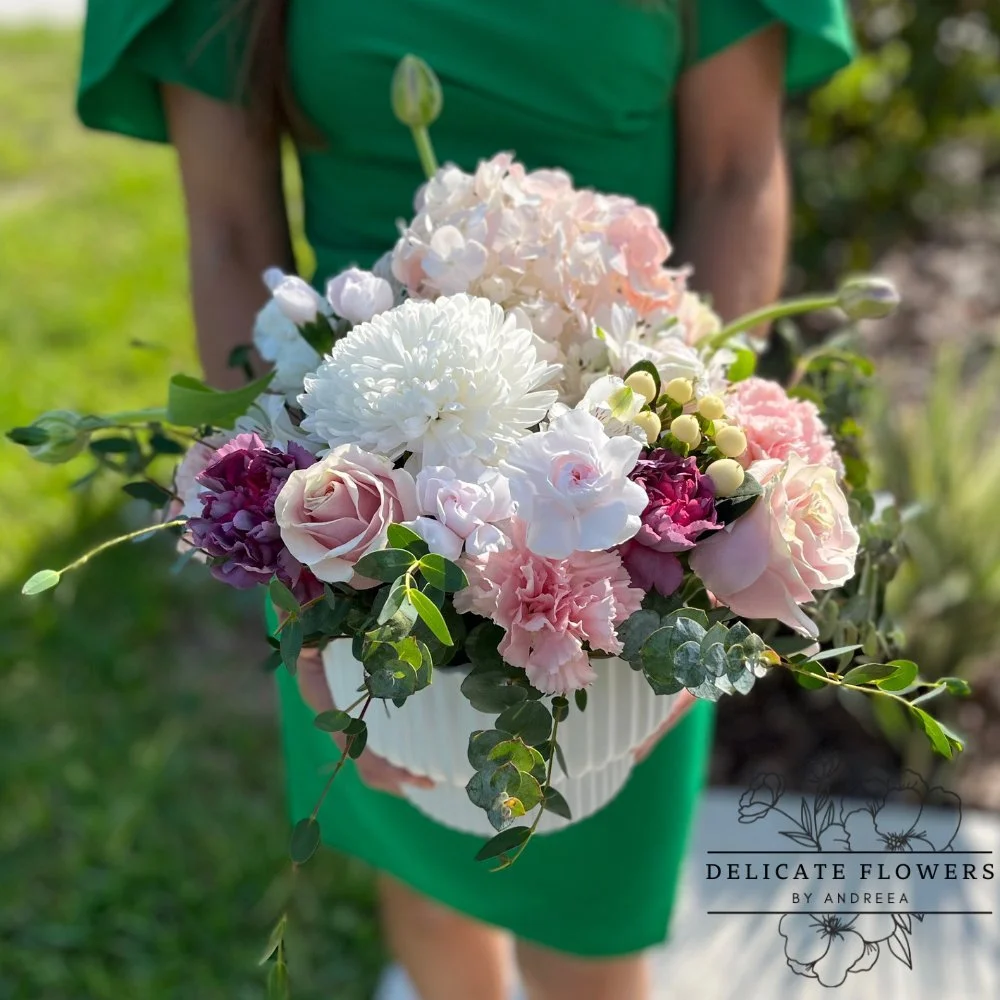 Table Arrangement centerpiece with blush and ivory roses, hydrangea, white chrysanthemums, pink accents, and eucalyptus