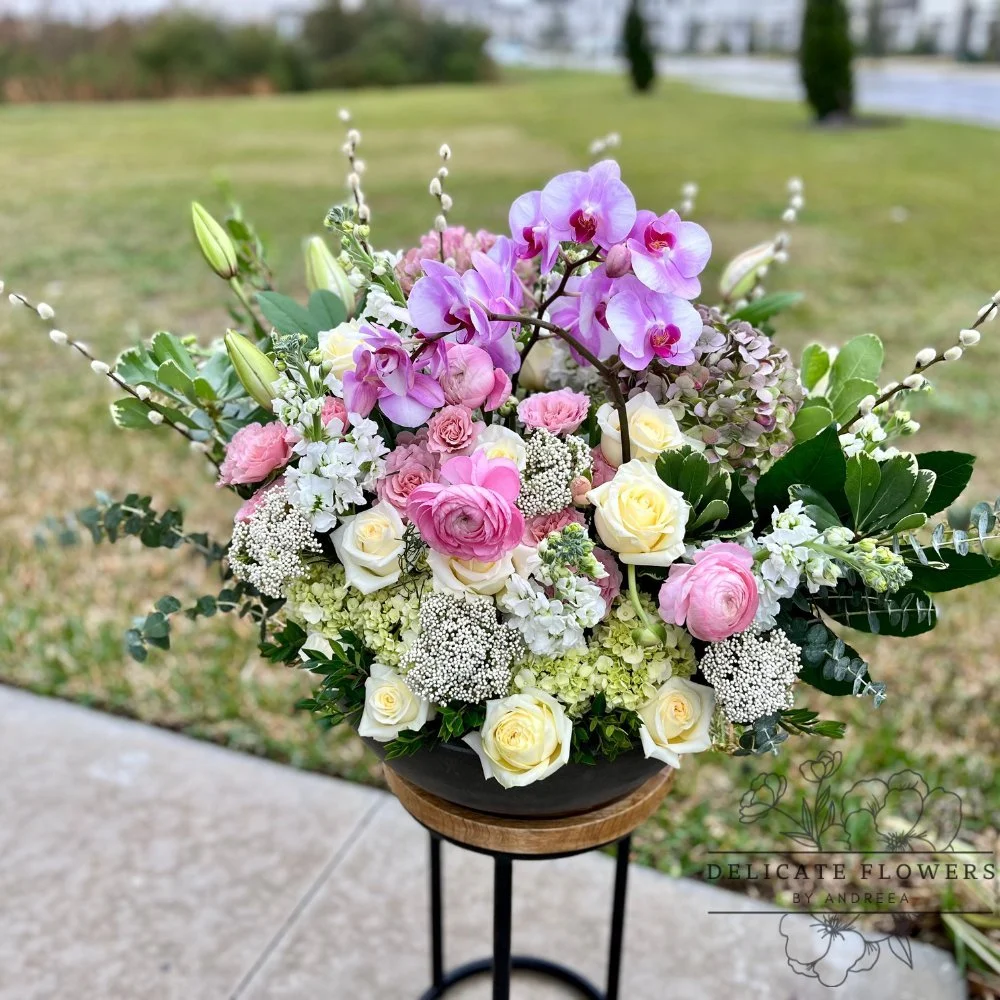 Majestic Orchid Elegance arrangement with purple orchids, pink and yellow roses, white blooms, and greenery