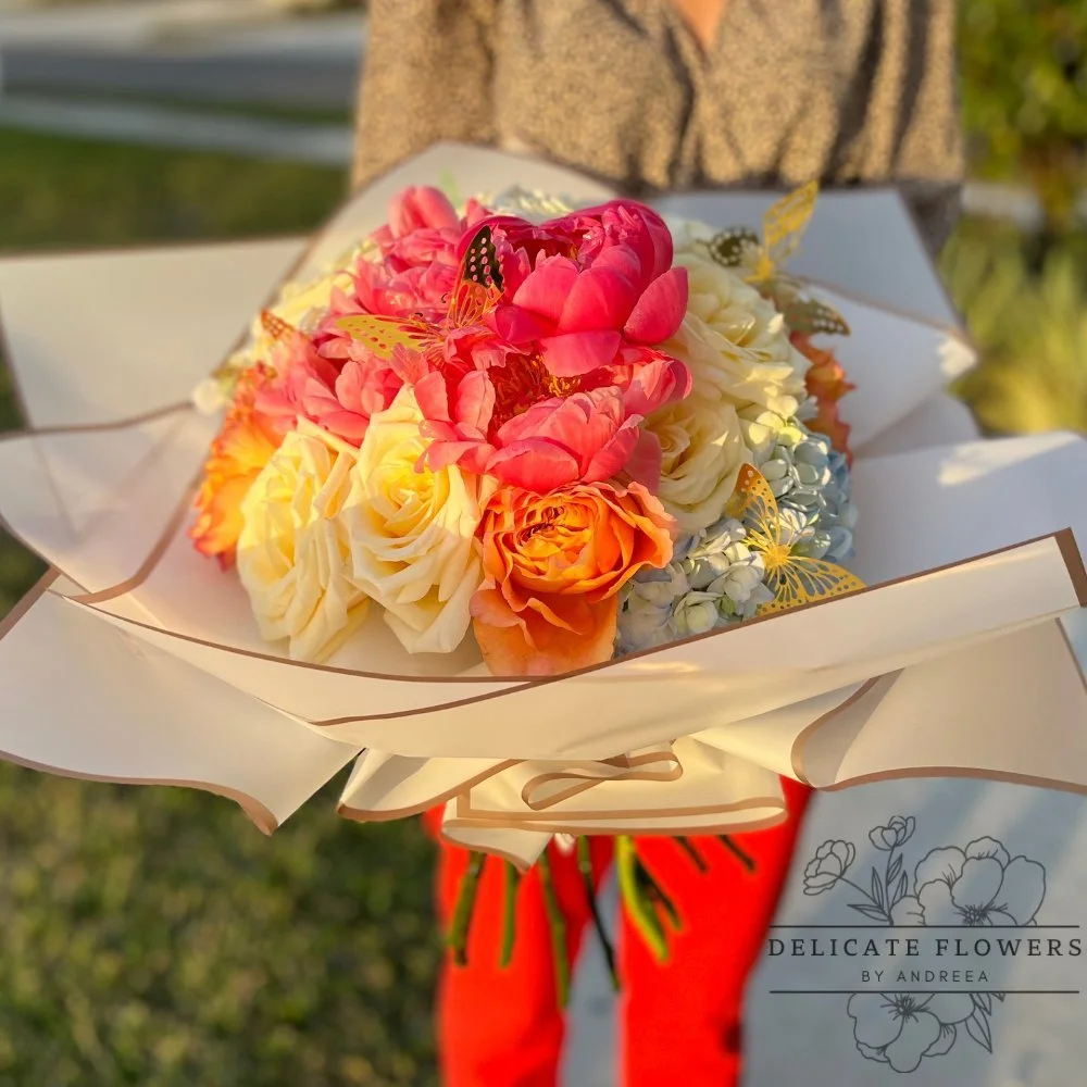 Peony Serenade bouquet with pink peonies, ivory and peach roses, hydrangea, and butterfly accents