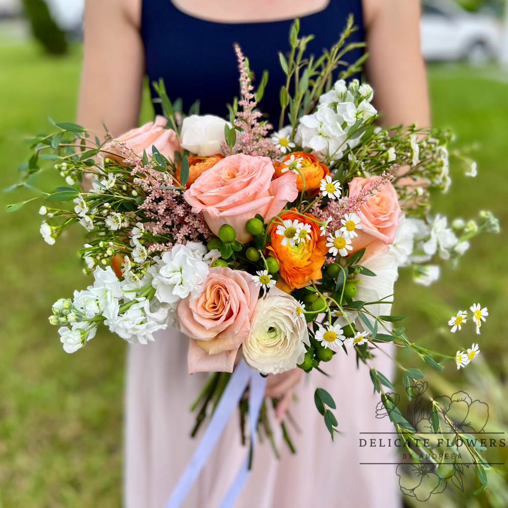 Peach Garden Whisper features blush and peach roses, delicate white blooms, bright ranunculus, daisies, and fresh greenery in a soft garden-style design full of natural charm. Handcrafted flower delivery in Wesley Chapel, FL