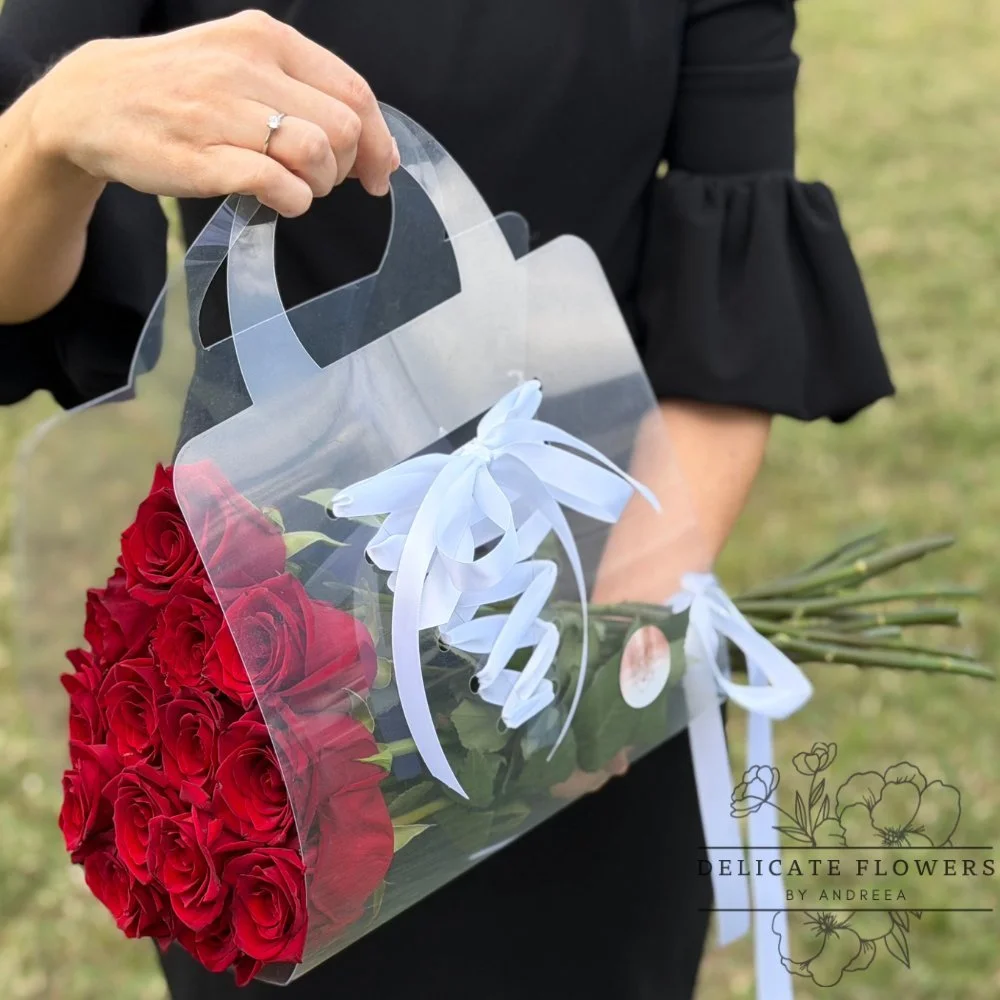 Red Rose Promise bouquet of red roses wrapped in a clear handle box with white ribbon and greenery. Handcrafted same-day in Wesley Chapel, FL. Call Delicate Flowers by Andreea.