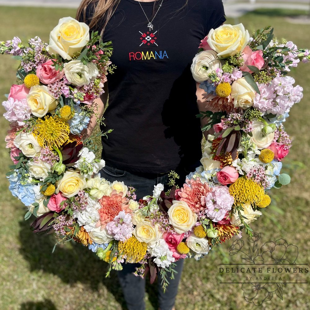 Pastel sympathy wreath with roses, ranunculus, hydrangeas, craspedia, and greenery