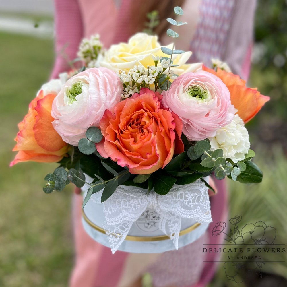 Peach Blush flower arrangement with peach roses, blush ranunculus, ivory blooms, and eucalyptus