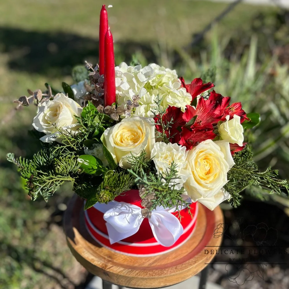 Winter Elegance holiday flower arrangement with red roses, white hydrangeas, yellow roses, and seasonal greenery
