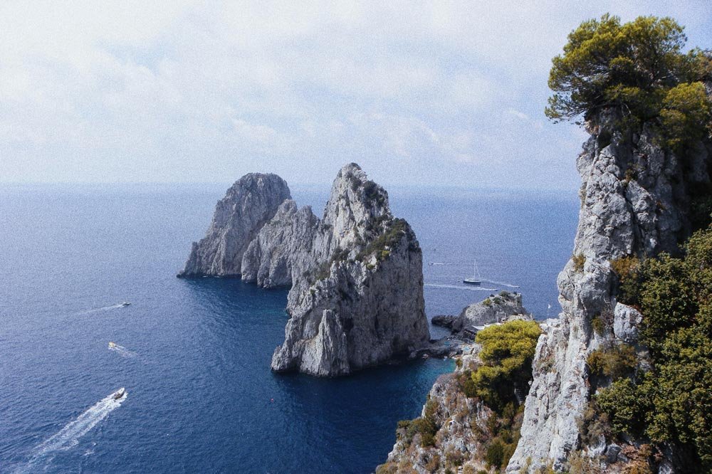 Rocks rising out of the ocean and rugged cliffs on the Amalfi Coast, Italy.