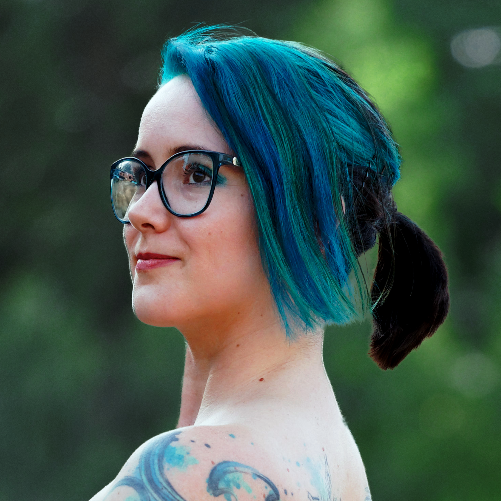 2DKiri with a ponytail looking off to the side and into the distance. Her shoulder tattoo is visible.