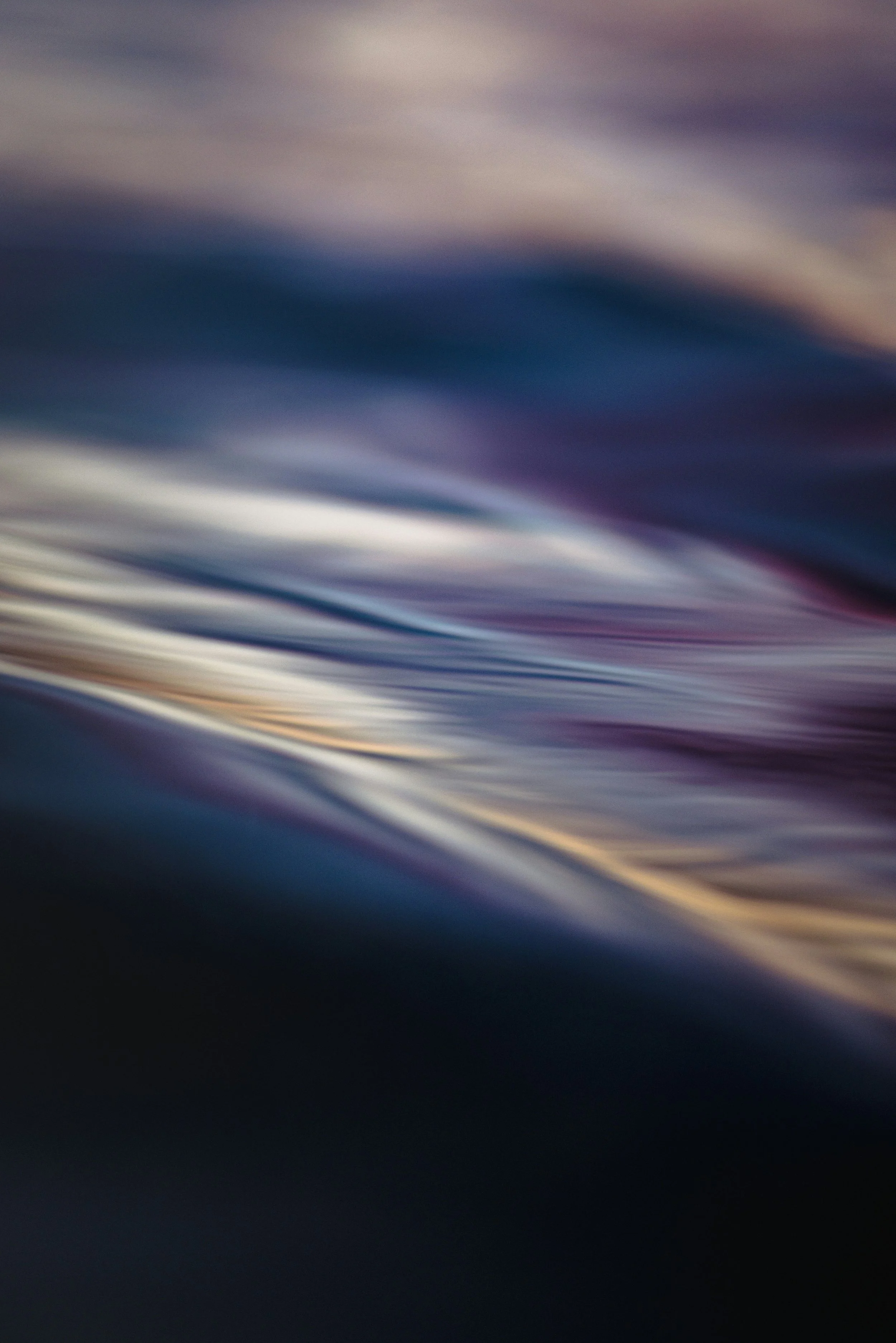 Abstract image of flowing water with smooth, wavy patterns and a gradient of colors including blue, purple, and cream.