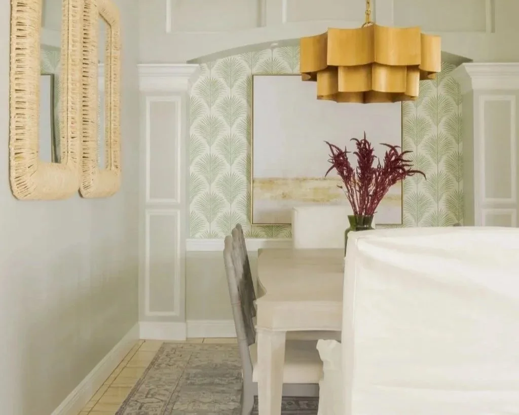 Dining room with neutral wall color and trim along with a statement wallpaper elevated by a gold chandelier.