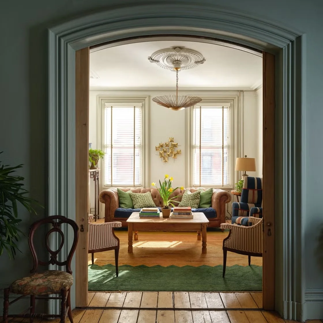 Warm and inviting living room styled with pops of color, architectural moulding, modern lighting.