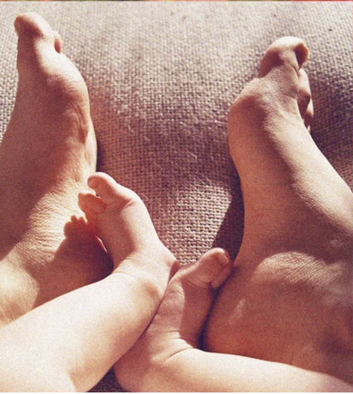 Adult and child feet nestled together on a blanket