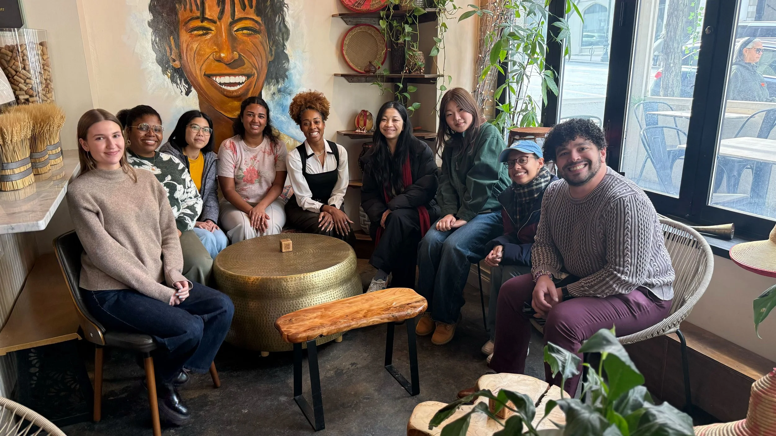 The Marlin Lab poses for a photo. All are seated at a couch or on chairs and they are all smiling.