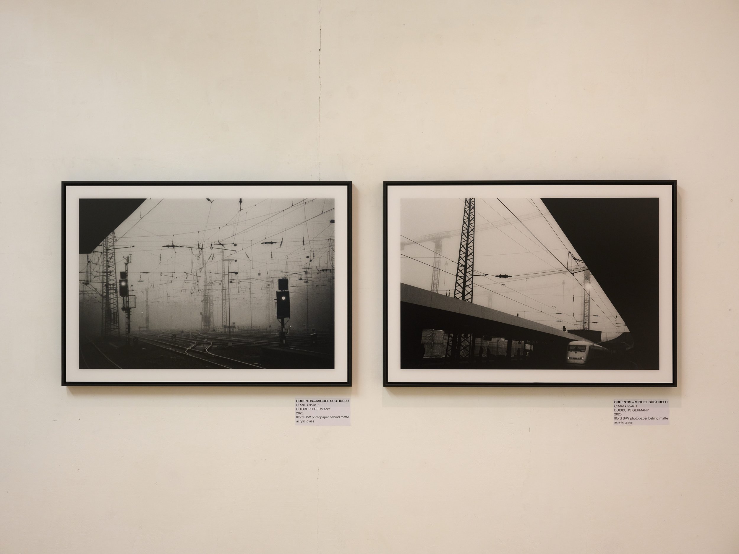 Two black and white photographs by Cruentis in black shadow gap frames on a white gallery wall at The Brick Lane Gallery in London