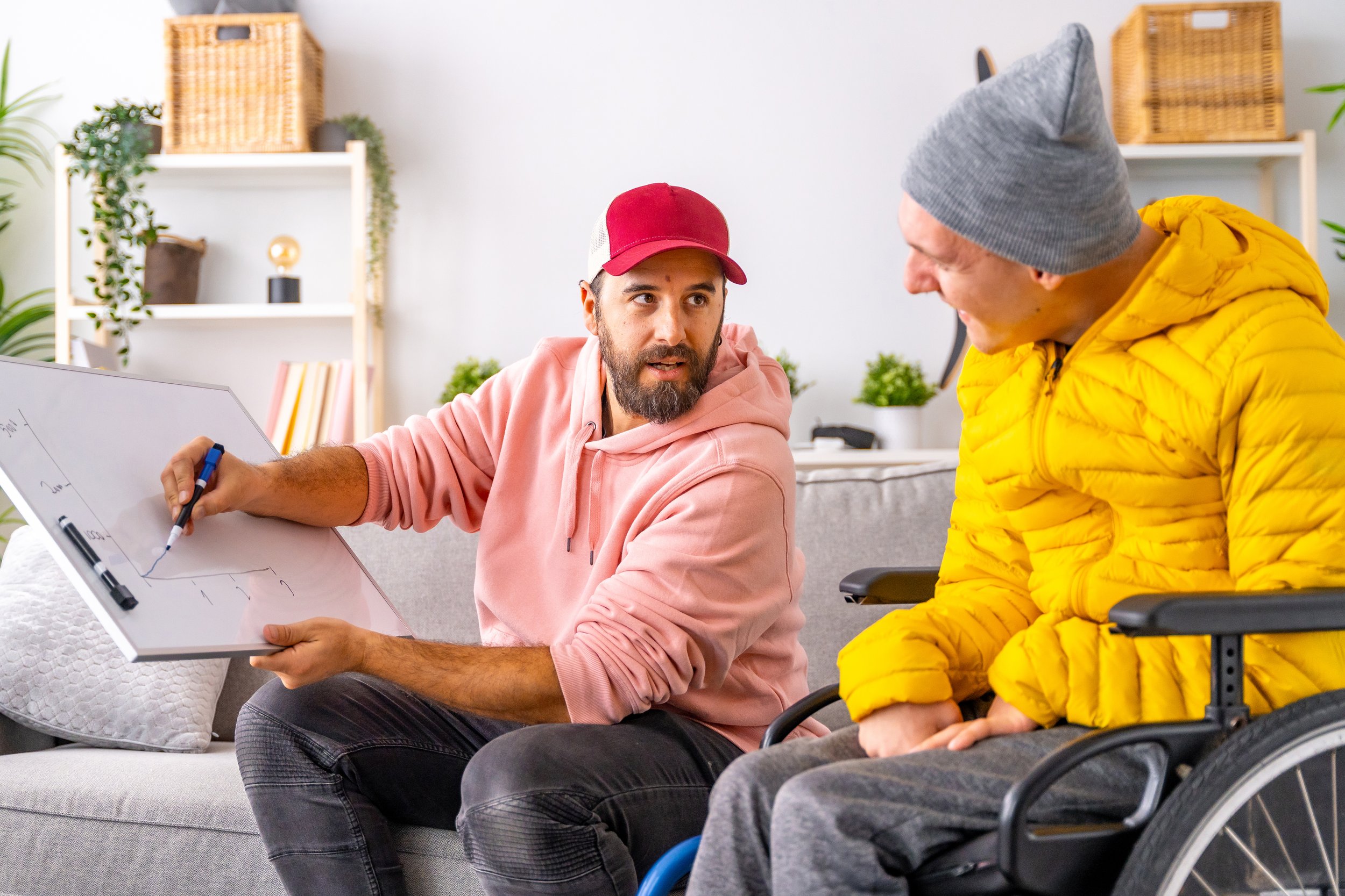 A direct support professional teaches a man with cerebral palsy to budget