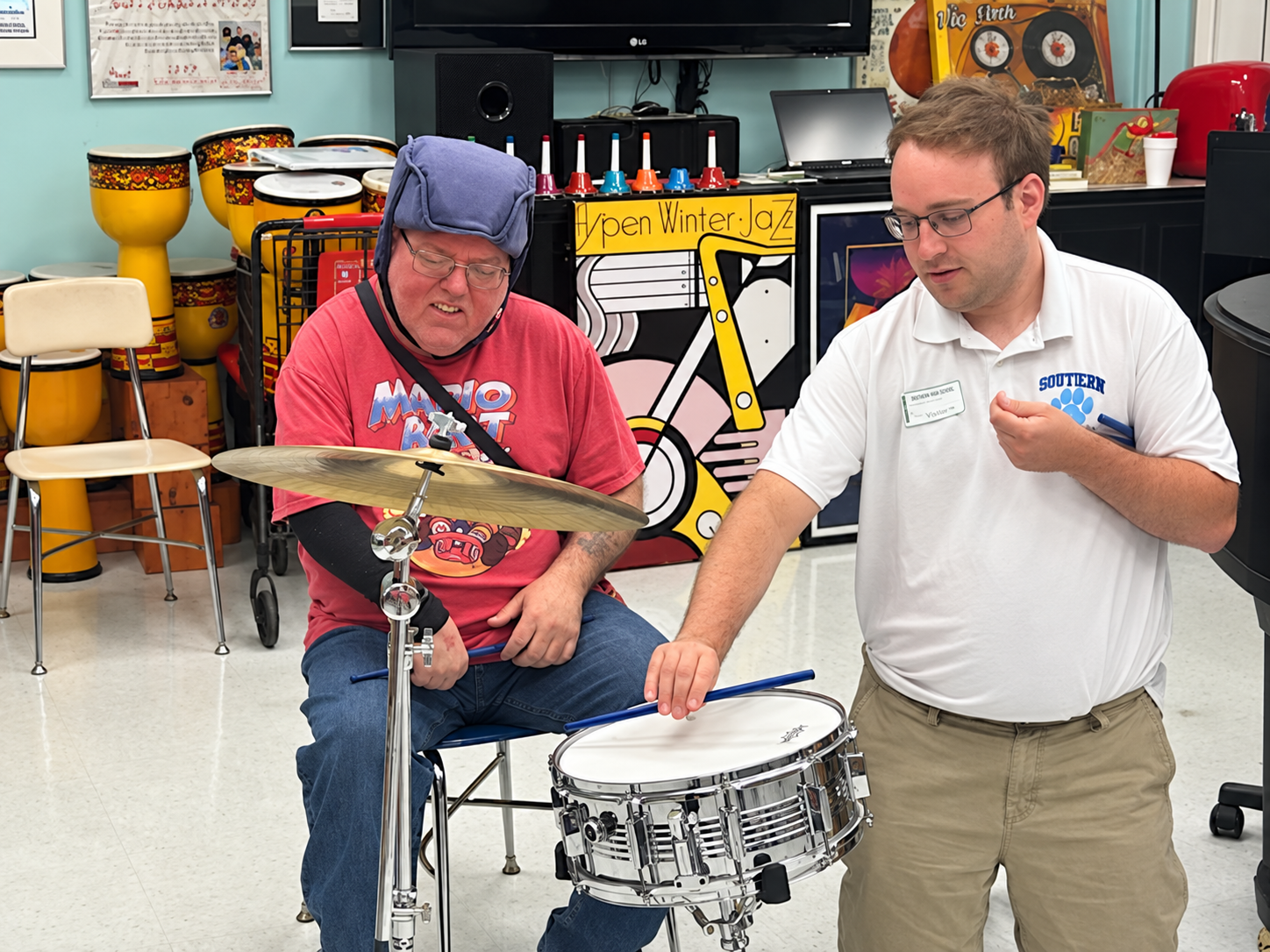 Jacob shows an older student how to use the snare drum