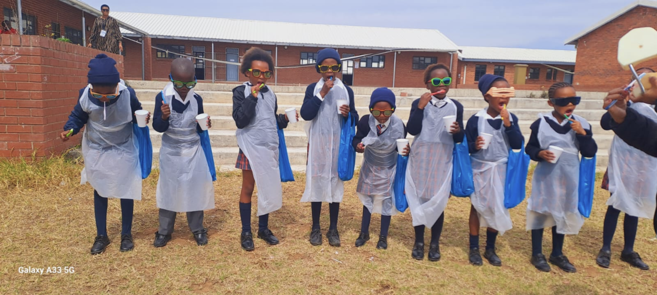 African children line up outside to brush their teeth.