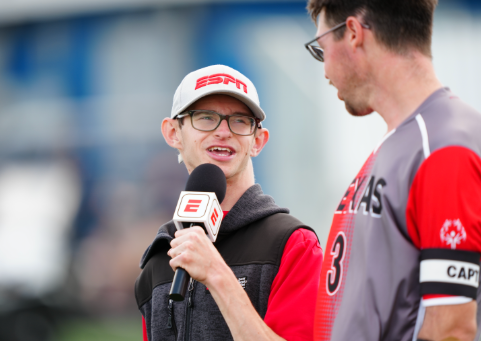 Wyatt Spalding wearing an ESPN hat and interviewing a MLB player