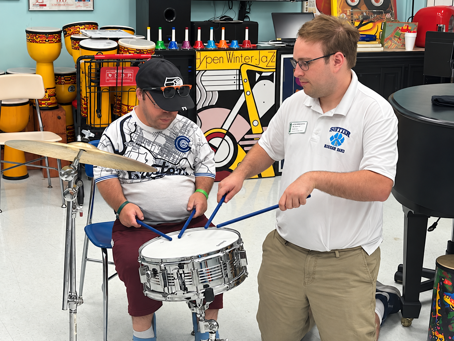 Jacob works with another student on proper drumming technique