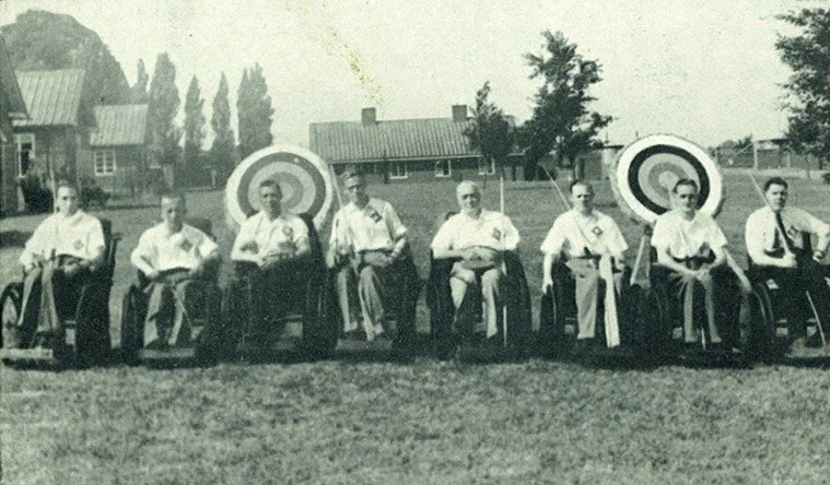 An old photo or archers in wheelchairs