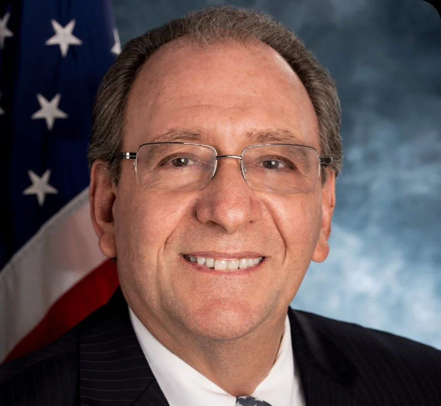 Portrait of Neal Romano in front of the American Flag