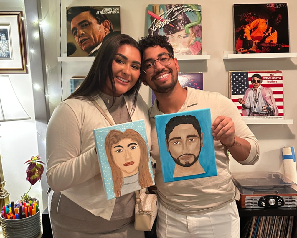 Couple shows off their portraits of each other