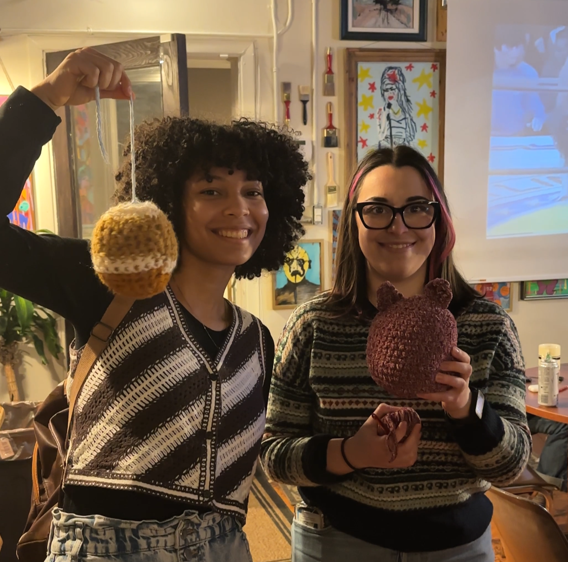 Two attendees show off their yarn creations.