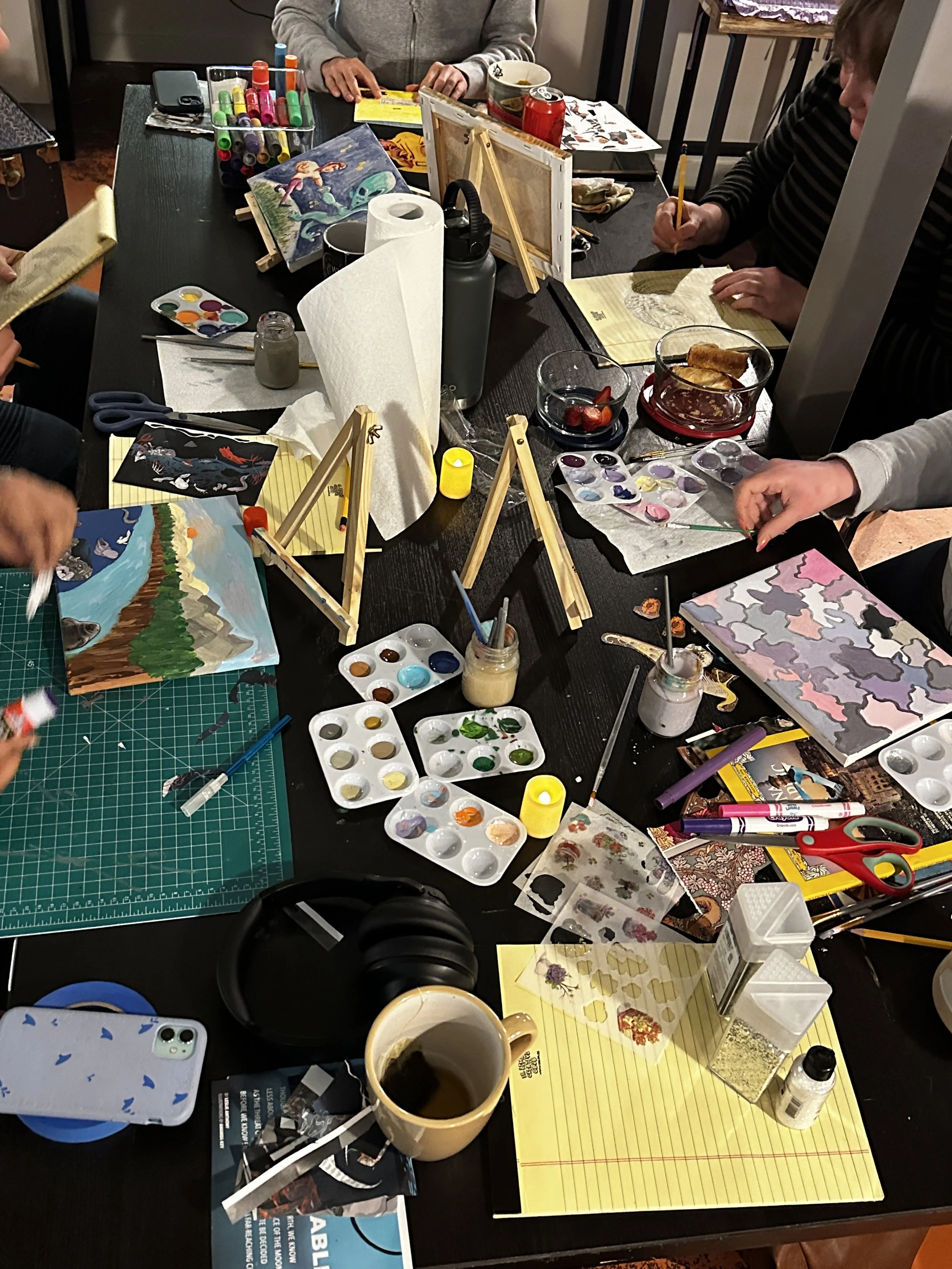An overhead shot of a table full of people painting.