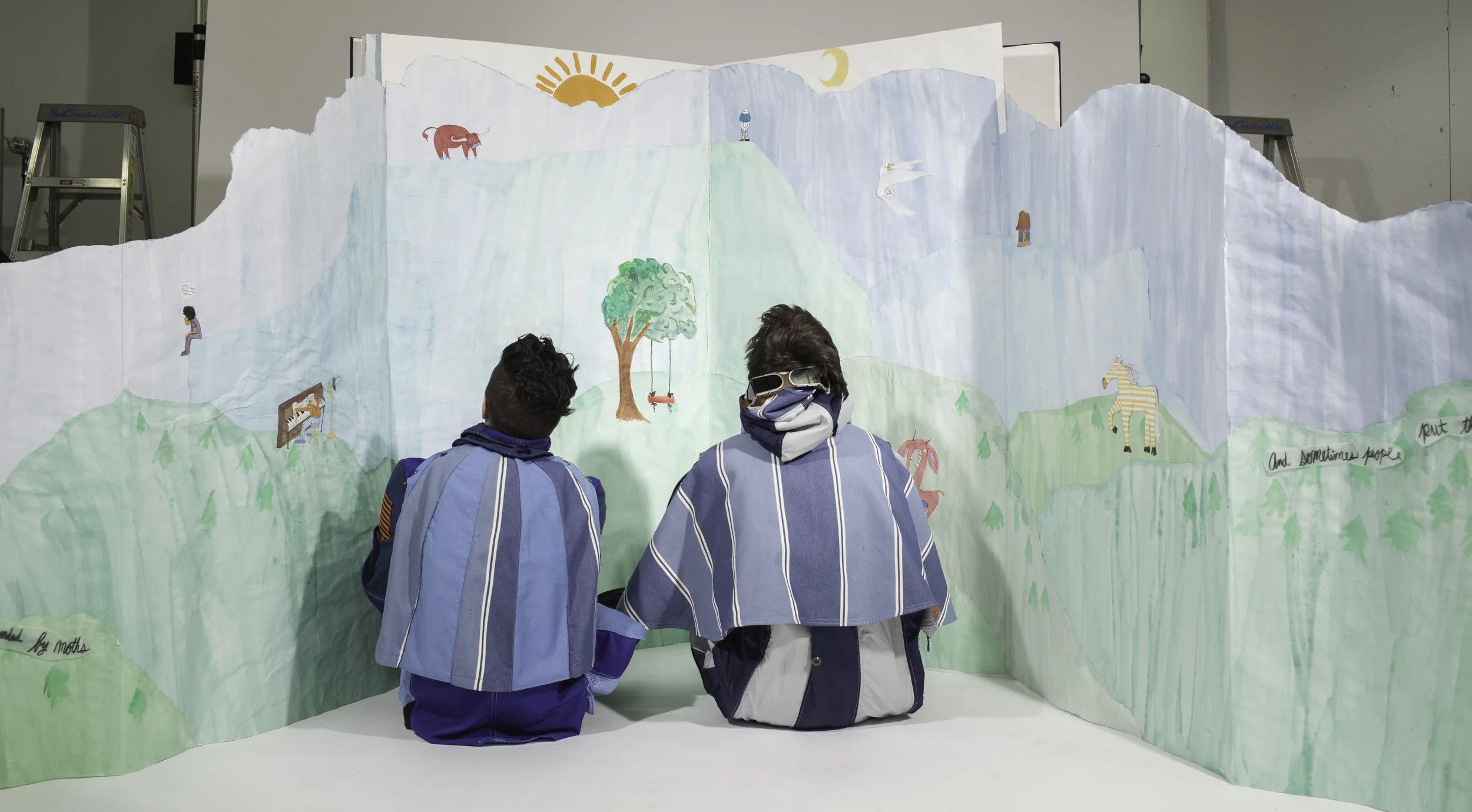 pop up book mountains unfolding with two people sitting infront of the lifesized book