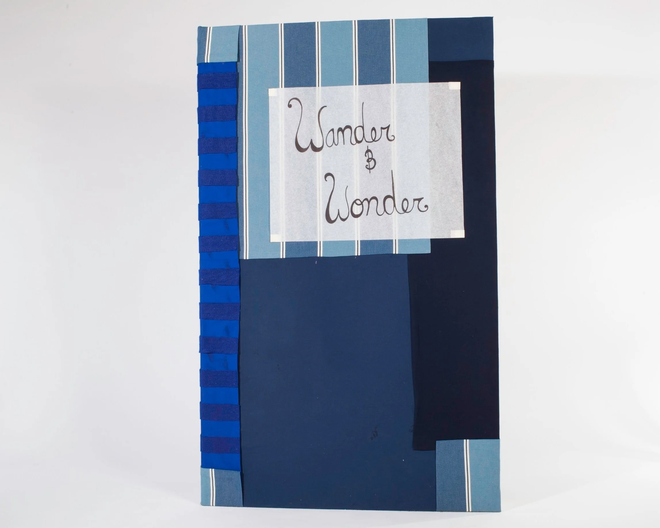 gaint blue collaged book cover with "wander and wonder" written in script