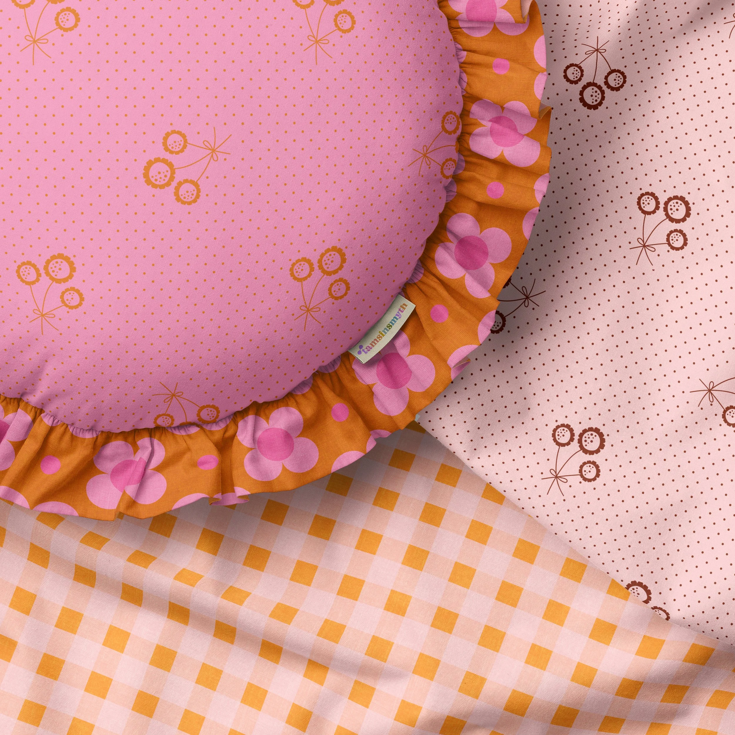 A cozy ruffled cushion and flat fabrics featuring a retro collection of designs in pinks and rust