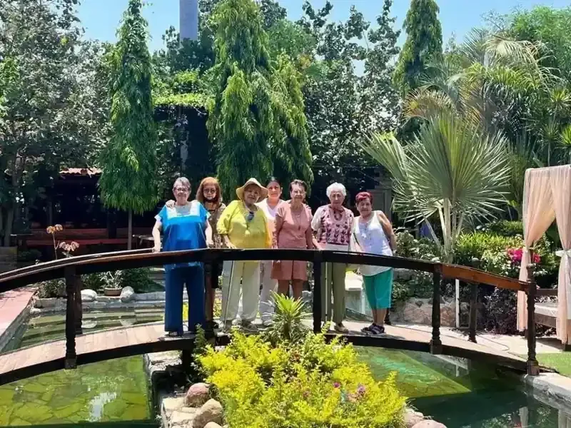Adultas mayores y acompañantes en el jardín de Las Maravillas