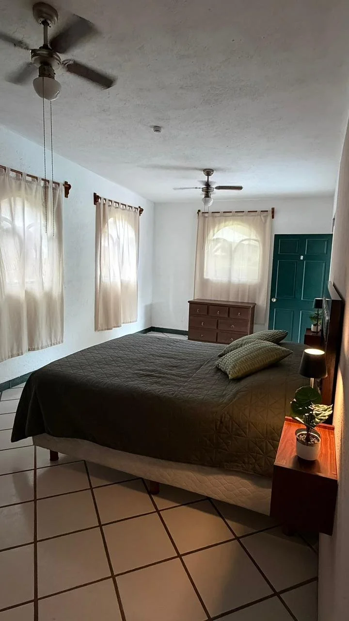 Habitación con cama, ventanas y ventilador de techo en la sucursal Chiconcuac de Las Maravillas