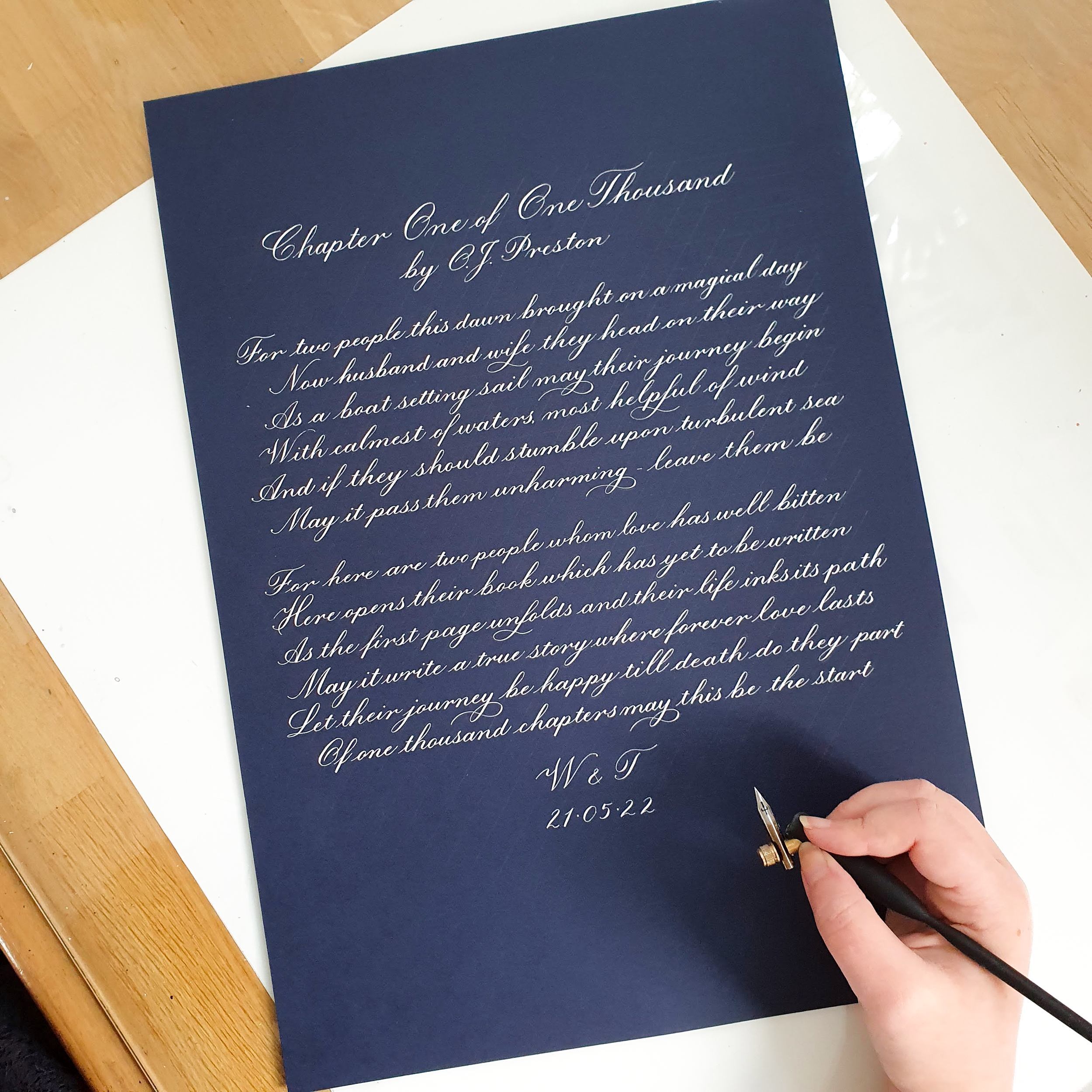 Book passage written in calligraphy on navy blue paper with white ink.