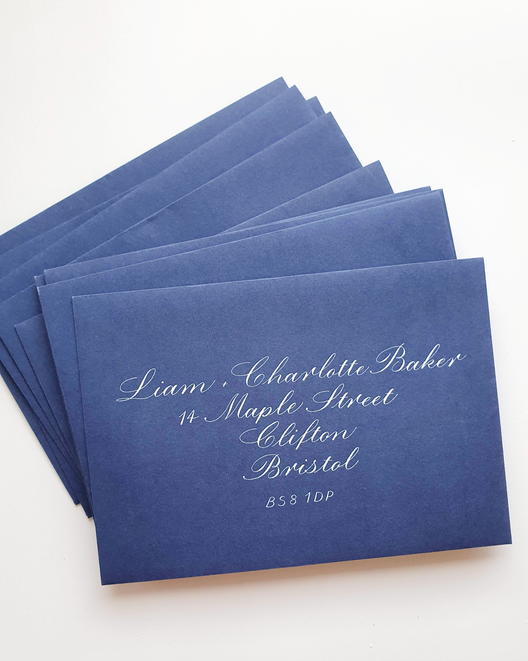 Navy blue envelopes with address on the front written in copperplate calligraphy.