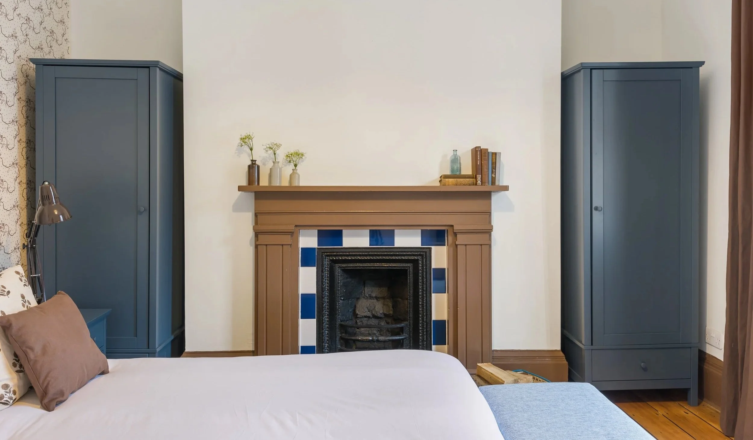 Heritage bedroom renovation in Liverpool featuring restored fireplace, bespoke joinery and North Wales coastal-inspired tones.