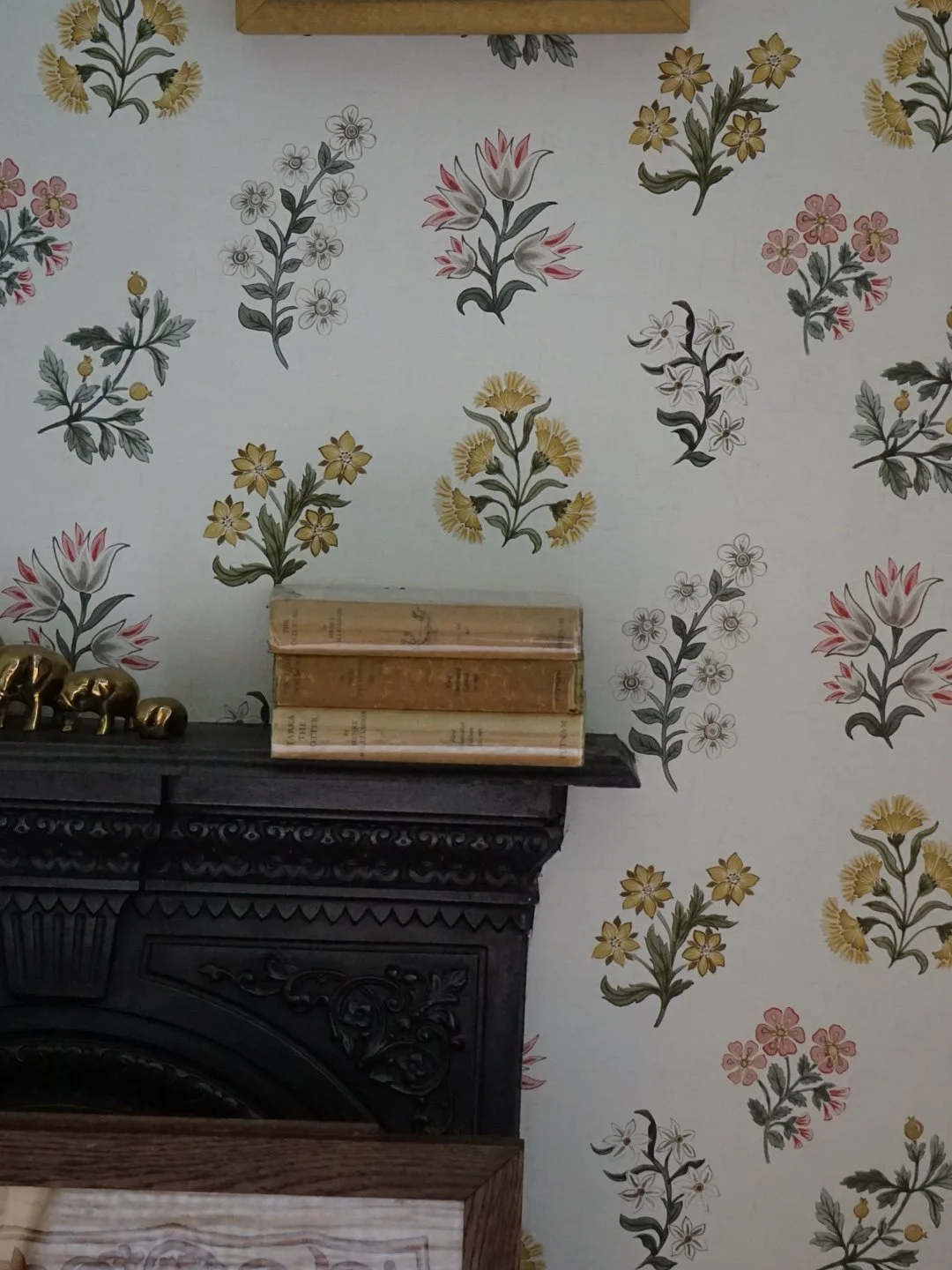 Anglesey country house refurbishment featuring decorative floral wallpaper by clarke and clarke, restored cast iron fireplace and layered heritage styling by Stiwdio Interior Design, North Wales.