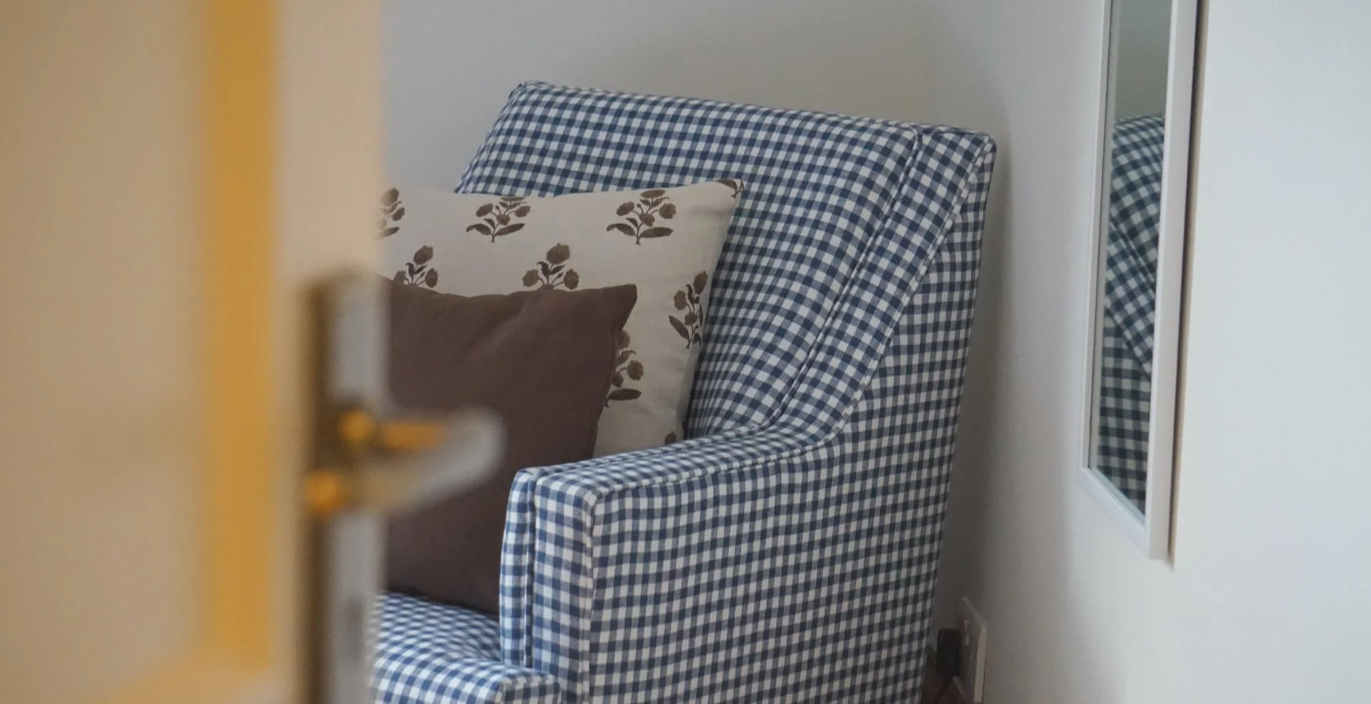 Blue gingham accent chair in a Liverpool heritage renovation blending classic British design with North Wales inspired interiors.