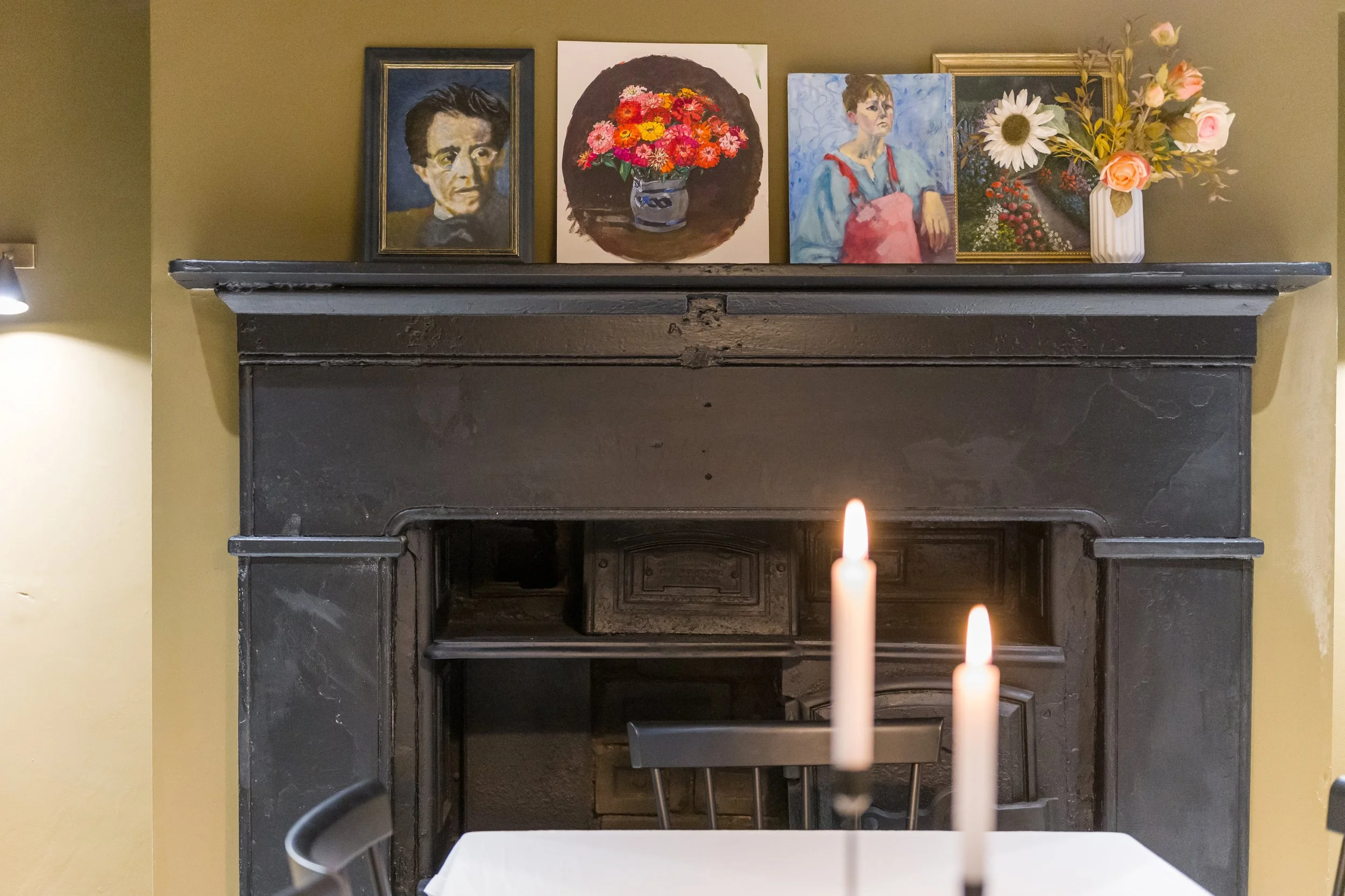 Restored Georgian fireplace styled with vintage artwork in a Liverpool heritage renovation by Stiwdio Interior Design.