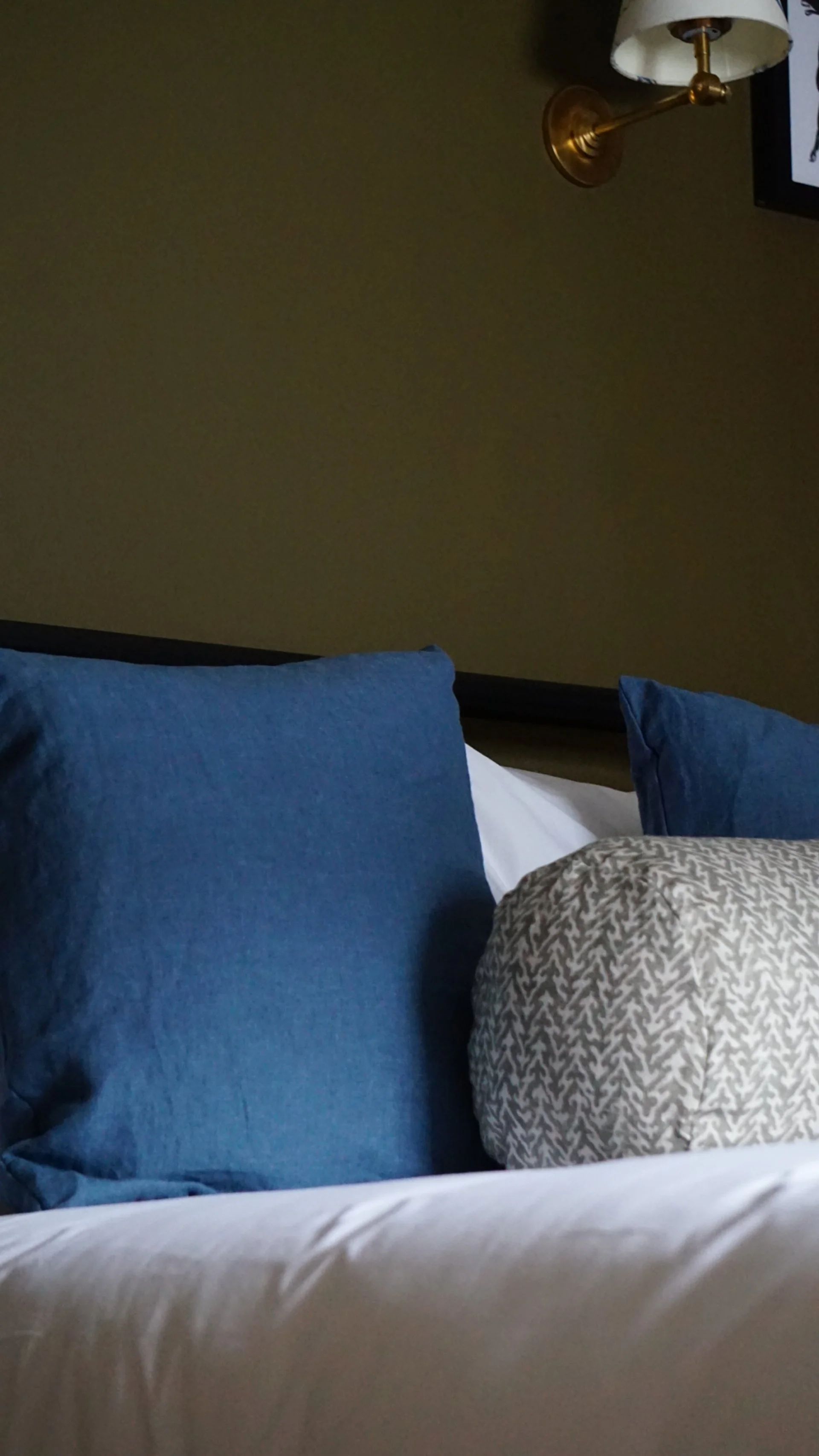 cushions on bed in bue with patterned bolster cushion