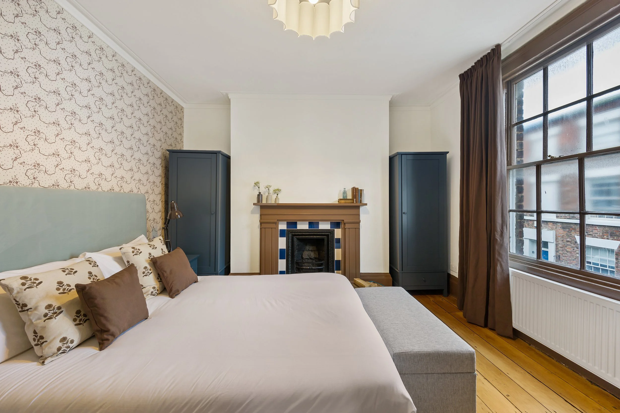 Heritage Georgian bedroom interior featuring blue cabinetry, period fireplace and bespoke styling by Stiwdio Interior Design, serving clients in Wales and Liverpool.