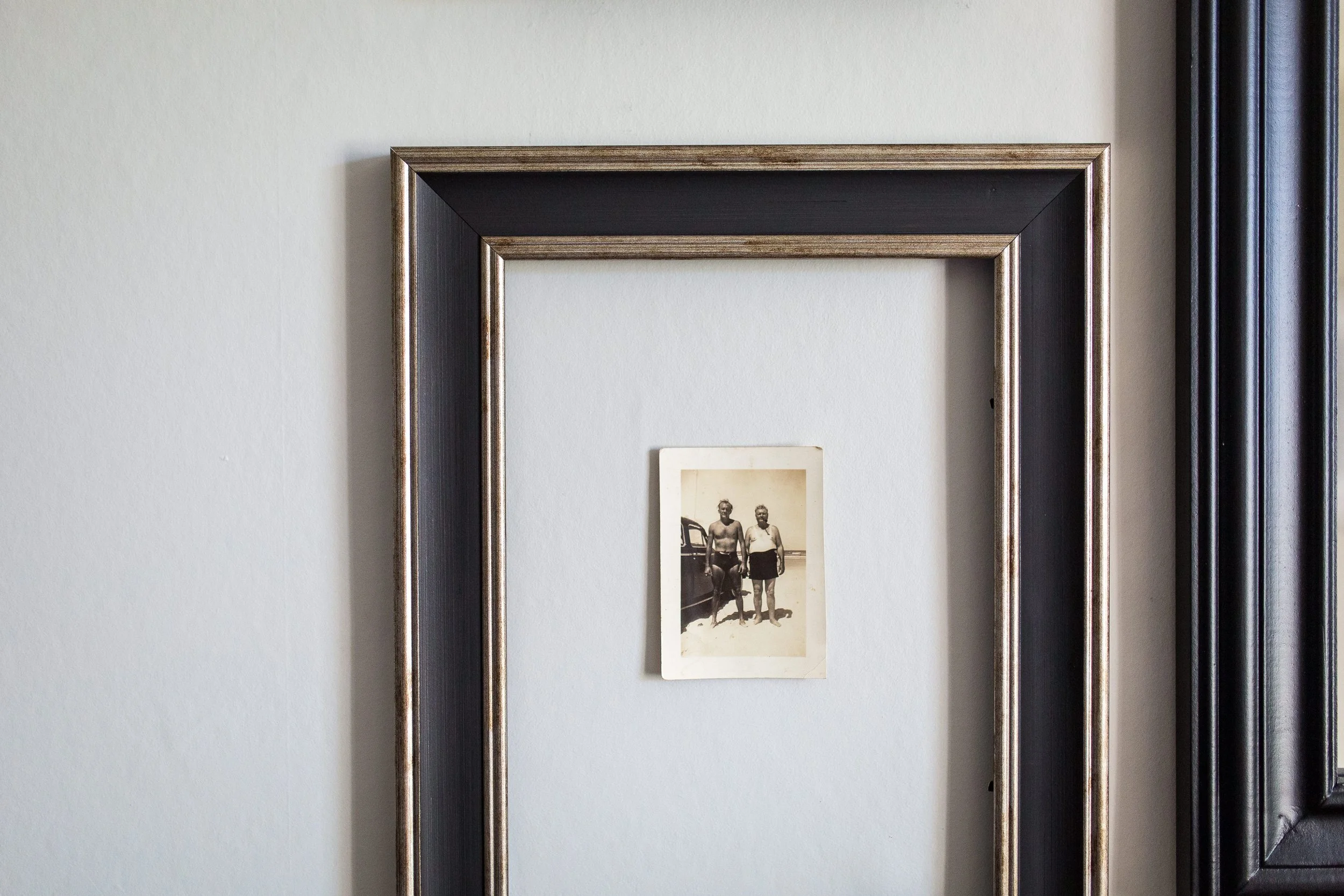 Country house refurbishment detail featuring a framed vintage family photograph set within a deep, heritage-style mount and dark timber frame. This thoughtful interior design moment blends traditional craftsmanship with curated storytelling, celebrat