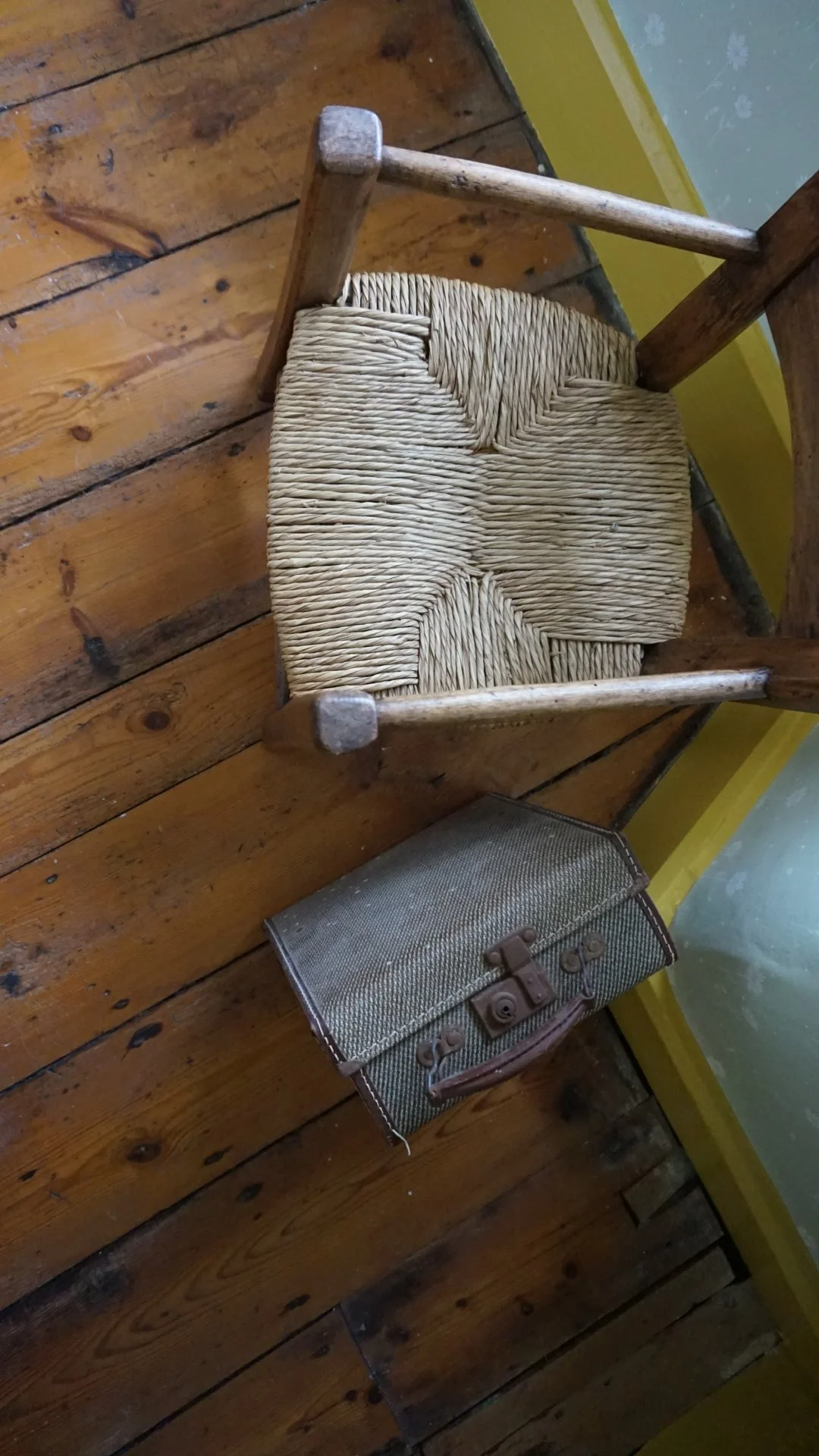 Anglesey country house refurbishment featuring original timber floorboards, vintage suitcase styling and woven rush seating by Stiwdio Interior Design, North Wales.