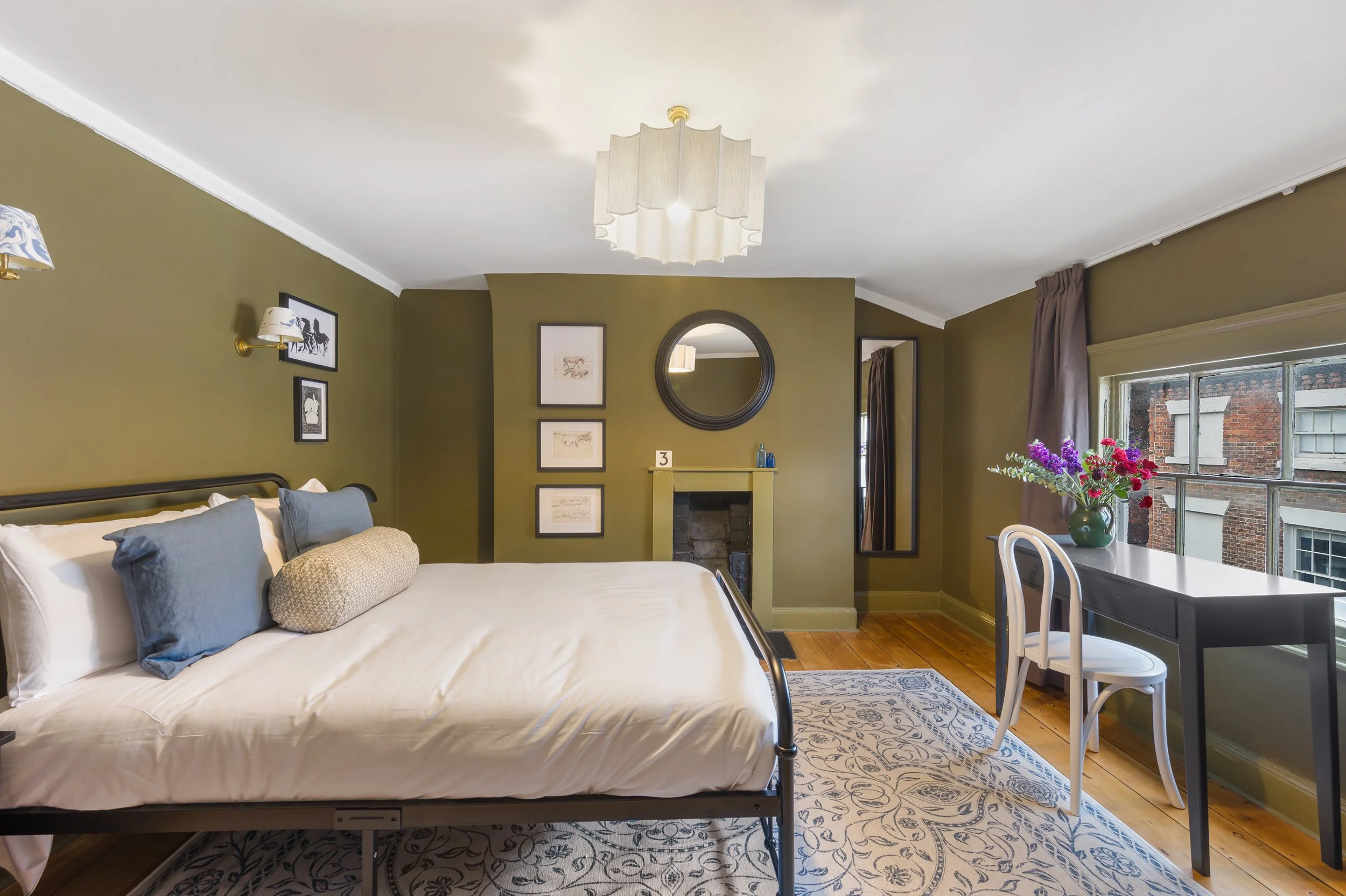 Green bedroom with soft tones and black framed artwork in liverpool georgian quarter home