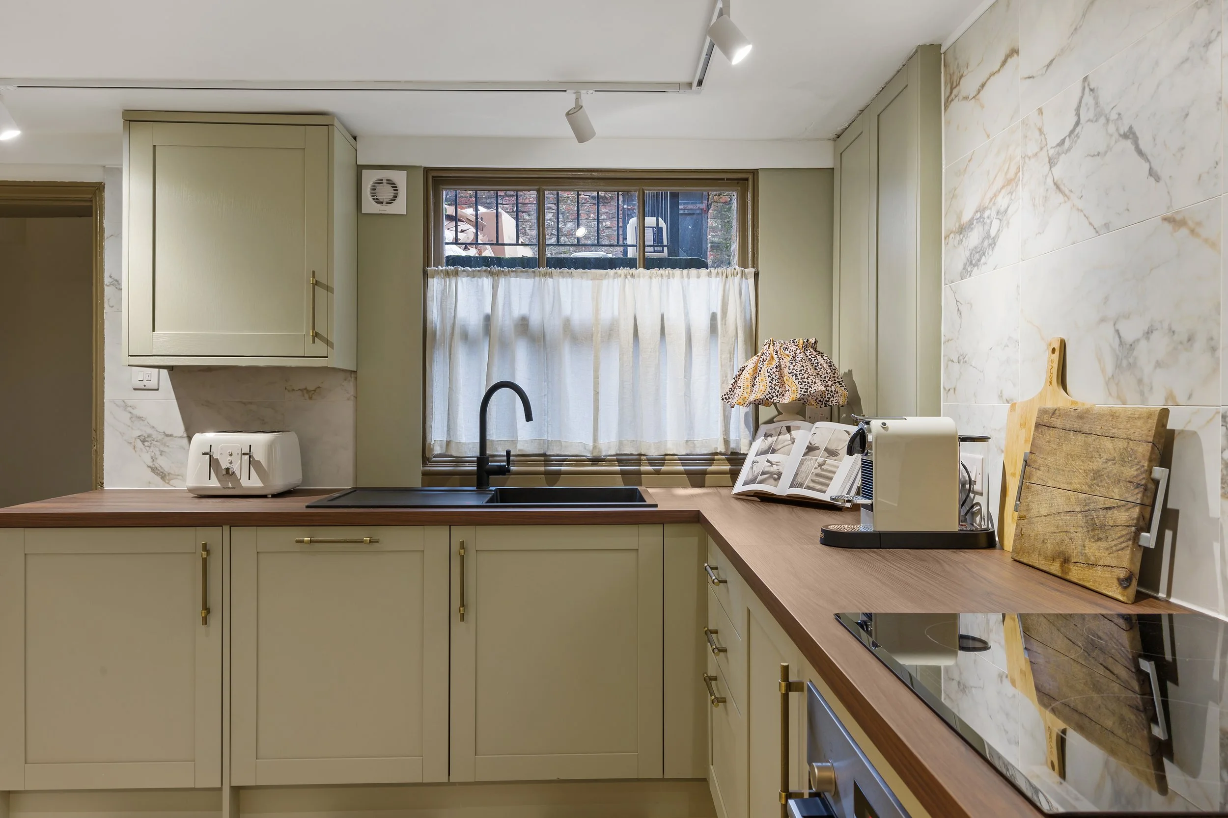 Marble splashback kitchen with dark wood worktops and linen cafe curtain in georgian liverpool