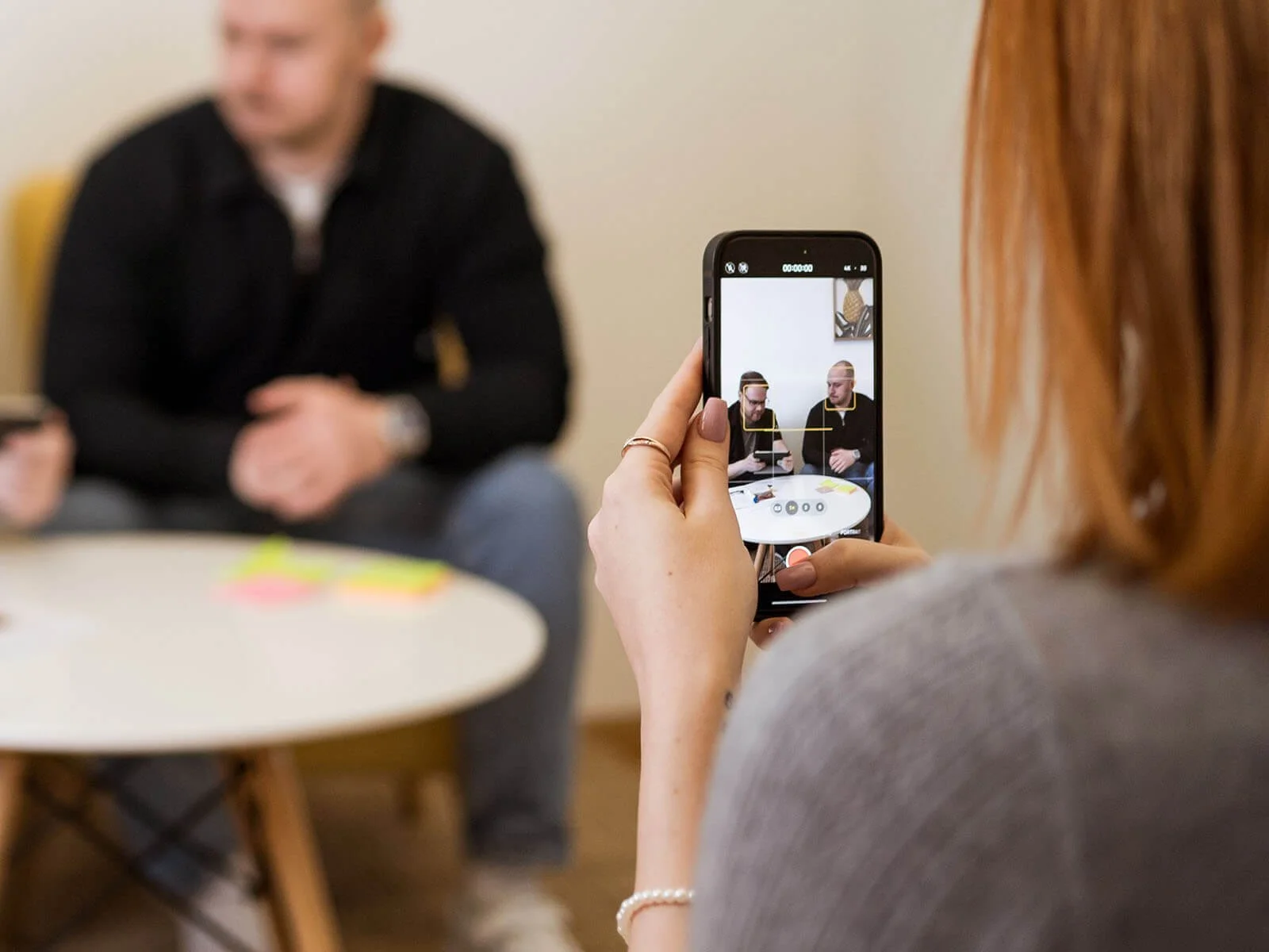 Bild zeigt die Aufnahme auf einem Smartphone und dahinter verschwommen die Szene