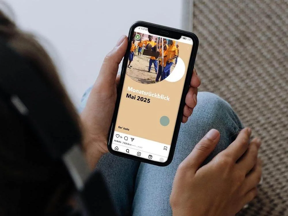 Eine Person hält ein Handy in der Hand auf dem ein Reel zum Monatsrückblick Mai von forikolo abgespielt wird.