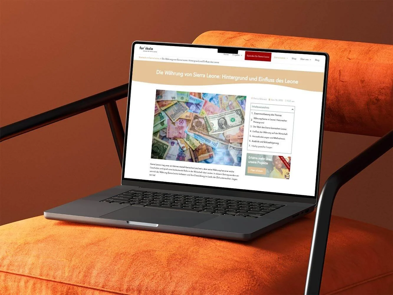 Ein Laptop steht auf einem orangenen Sessel. Auf dem Laptop ist ein Blogbeitrag zum Thema "Währung in Sierra Leone" auf forikolo.de geöffnet.