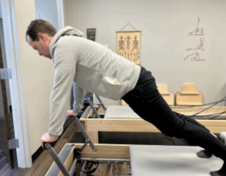 Man doing pilates on a reformer at Babylon Barre