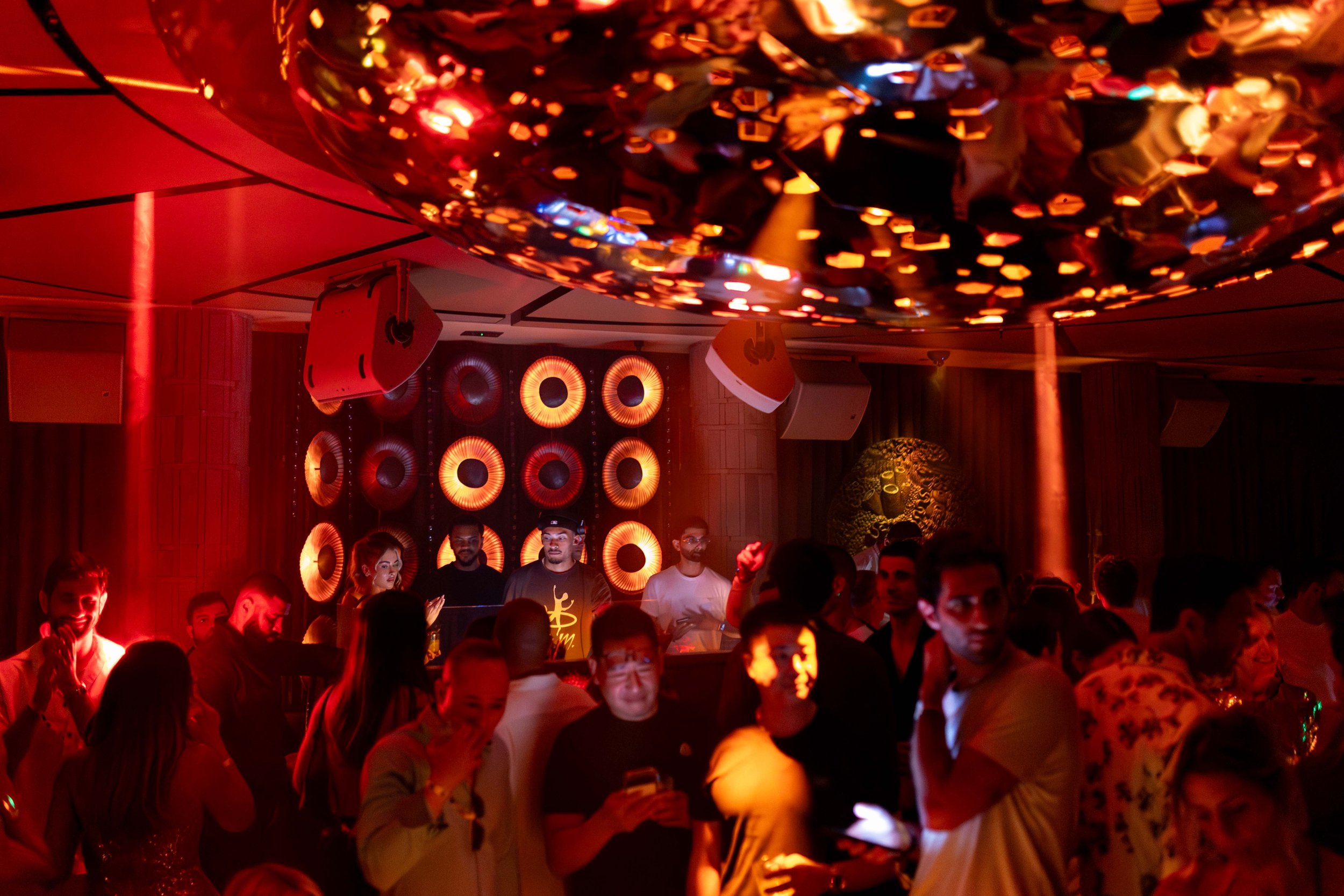 Image of CASA NEOS Lounge, with people dancing and the DJ playing music.