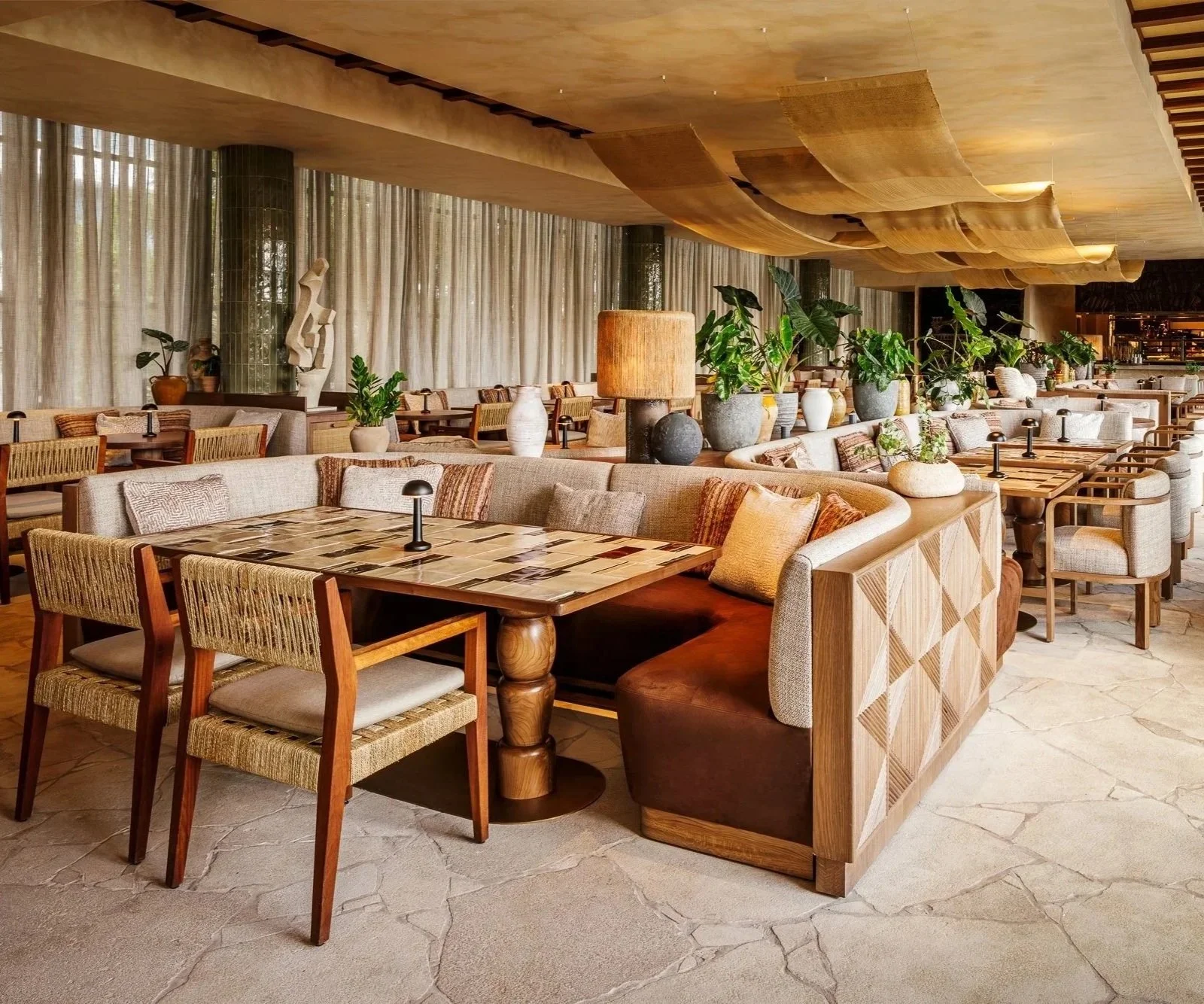 Neutral restaurant decor with vibrant plants and artwork to capture the dining setting of CASA NEOS restaurant..